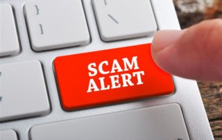 A red scam alert button on keyboard, signifying job scams.