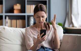 Confused angry young woman having problem with phone.