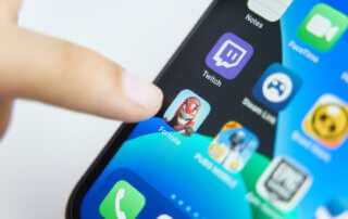 Finger pointing to Fortnite app on iPhone.